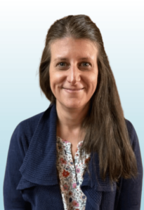 Smiling adult with long brown hair looks at the camera