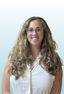 woman with light brown hair and glasses smiling at the camera