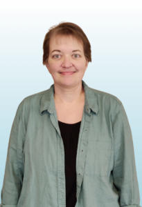 Adult with short brown hair smiling at the camera.